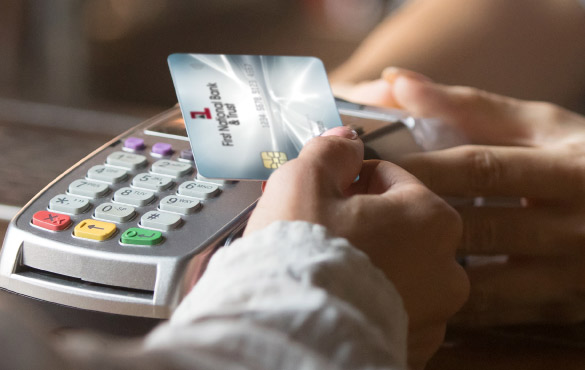 Woman making a payment with First National Bank & Trust card